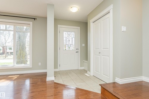 Foyer entrance featuring a decorative glass door, tiled flooring, and a double-door closet - 8530 76 Avenue, Edmonton, AB - Indoor Photo Showing Other Room