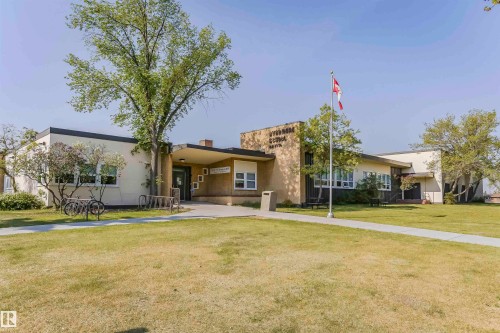 Single-story commercial building featuring a cream-colored facade with dark trim and a flat roof - 8530 76 Avenue, Edmonton, AB - Outdoor