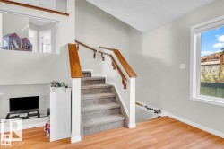 Staircase featuring wood handrails and carpeted treads - 