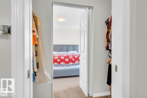 Bedroom featuring a light gray upholstered headboard and carpeted flooring - 21223 92 Avenue, Edmonton, AB - Indoor