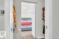 Bedroom featuring a light gray upholstered headboard and carpeted flooring - 