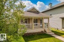 Charming residential exterior featuring a covered front porch with white railing, light-colored siding, and a brown shingle roof - 21223 92 Avenue, Edmonton, AB  - Outdoor With Deck Patio Veranda 