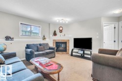 Living area with a corner fireplace featuring a tiled surround and white mantel - 