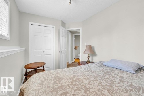 Bedroom featuring neutral wall colors, textured ceiling, a window with horizontal blinds, and a bi-fold closet door - 21223 92 Avenue, Edmonton, AB - Indoor Photo Showing Bedroom