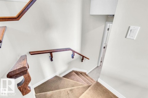 Carpeted staircase with contrasting wood railings and white walls - 21223 92 Avenue, Edmonton, AB - Indoor Photo Showing Other Room