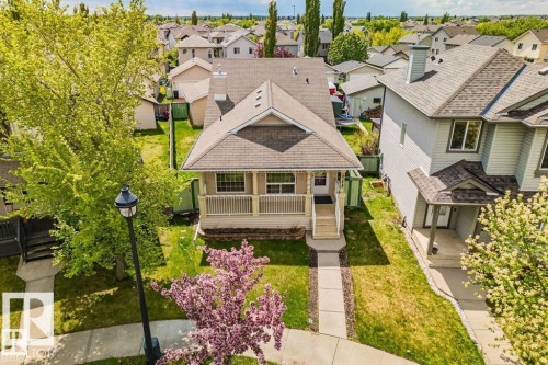 Front-facing residence with a covered porch, white railing, and a gabled roofline - 21223 92 Avenue, Edmonton, AB - Outdoor