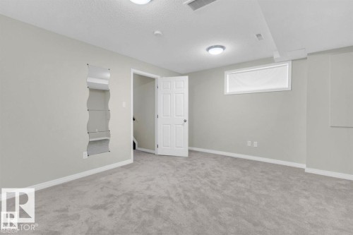 Spacious room featuring light gray carpet, neutral wall paint, and white trim - 21223 92 Avenue, Edmonton, AB - Indoor