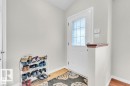 Entryway featuring a white door with decorative glass inserts, ceramic tile flooring, and a half-wall with a wood-finish cap - 21223 92 Avenue, Edmonton, AB  - Indoor Photo Showing Other Room 