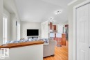 Open-concept living area featuring light wood-finish flooring, white trim, and vaulted ceilings - 21223 92 Avenue, Edmonton, AB  - Indoor Photo Showing Living Room 