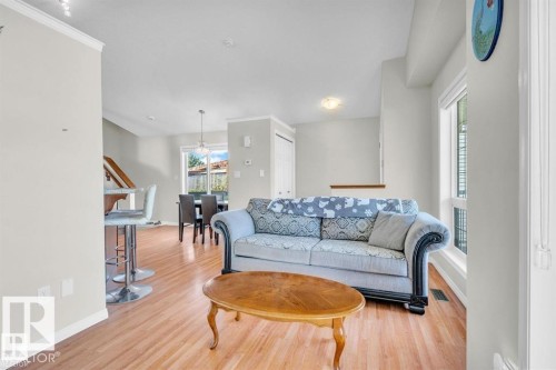 Open-concept living space featuring wood-finish flooring, white walls, and crown molding - 21223 92 Avenue, Edmonton, AB - Indoor Photo Showing Living Room
