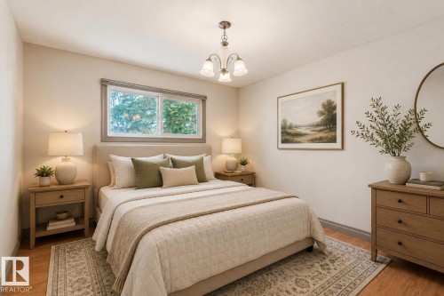 Bright room with wood-finish flooring, featuring a four-pane window with a gray frame, a ceiling-mounted light fixture with frosted glass shades, and light-toned wall paint - 10620 68 Avenue, Edmonton, AB - Indoor Photo Showing Bedroom