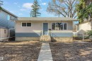 Bungalow-style residence featuring a light-colored stucco exterior with blue siding accents - 10620 68 Avenue, Edmonton, AB  - Outdoor 