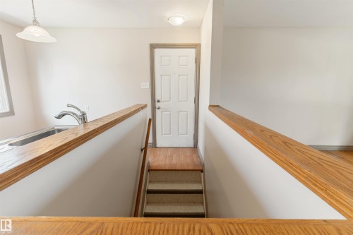 Interior staircase featuring wood-finish railings and carpeted treads - 10620 68 Avenue, Edmonton, AB - Indoor Photo Showing Other Room