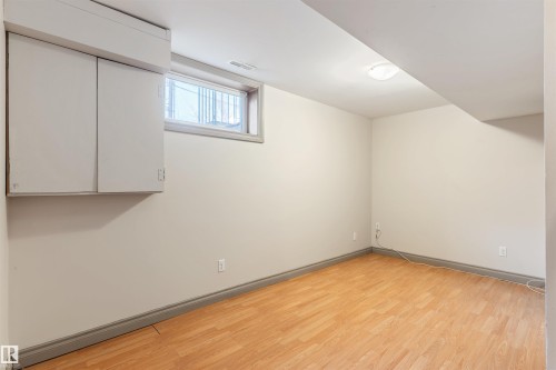Finished room featuring wood-finish flooring, white walls, and a built-in cabinet - 10620 68 Avenue, Edmonton, AB - Indoor Photo Showing Other Room