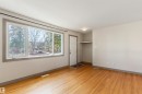 Living area featuring wood-finish flooring, a large multi-pane window, and neutral wall tones - 10620 68 Avenue, Edmonton, AB  - Indoor Photo Showing Other Room 