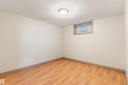 Room featuring light wood-finish flooring, neutral painted walls, and a recessed window with grey trim - 10620 68 Avenue, Edmonton, AB - Indoor Photo Showing Other Room