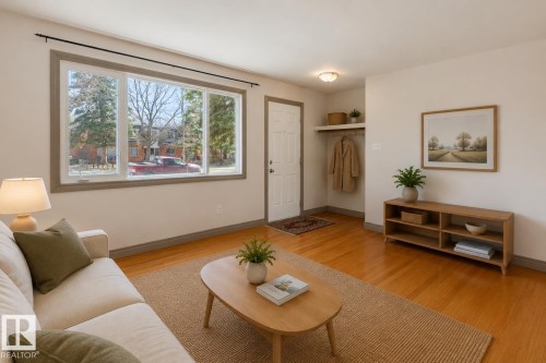 Living area featuring wood-finish flooring, a large multi-pane window, and a built-in entry shelf with a hanging rod - 10620 68 Avenue, Edmonton, AB - Indoor Photo Showing Living Room