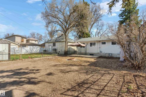 Expansive yard space featuring a concrete patio, a storage shed, and mature trees - 10620 68 Avenue, Edmonton, AB - Outdoor