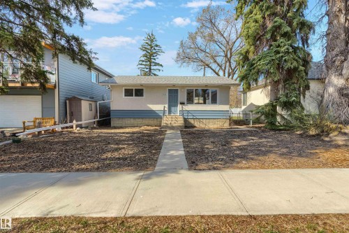 Single-story property featuring a light-colored exterior with a blue accent band and a gray roof - 10620 68 Avenue, Edmonton, AB - Outdoor
