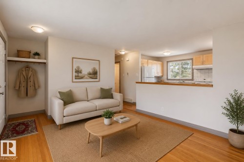 Open-concept living area featuring wood-finish flooring and a built-in coat rack with shelving - 10620 68 Avenue, Edmonton, AB - Indoor Photo Showing Living Room