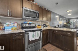 Kitchen featuring wood-finish cabinetry, light-toned countertops, tile backsplash, and stainless steel appliances - 