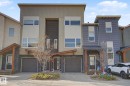 Modern townhouse exterior featuring multi-toned siding, stone accents, and a covered entryway - 210 401 Southfork Drive, Leduc, AB  - Outdoor With Facade 