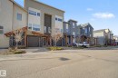Modern exterior featuring mixed-material siding, a single-car garage, and multiple large windows - 210 401 Southfork Drive, Leduc, AB  - Outdoor 