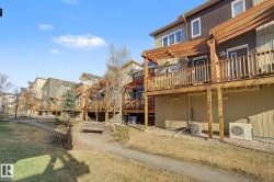 Rear exterior featuring a multi-level wood deck with pergola, gravel landscaping, and a paved walkway - 