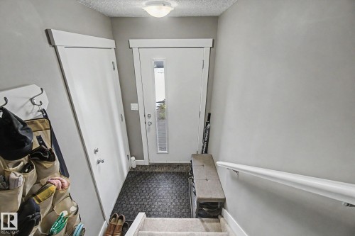 Entryway featuring a solid core door, sidelight window, flush mount ceiling light, and light gray wall paint - 210 401 Southfork Drive, Leduc, AB - Indoor Photo Showing Other Room