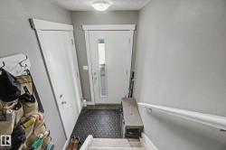 Entryway featuring a solid core door, sidelight window, flush mount ceiling light, and light gray wall paint - 