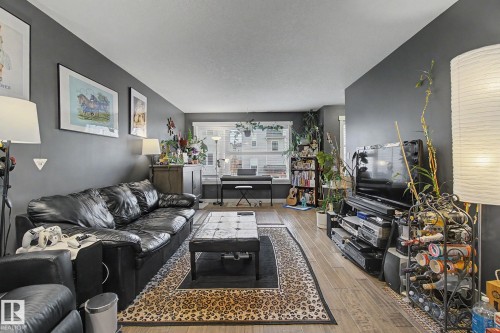 Spacious living area featuring dark gray walls and wood-finish flooring - 210 401 Southfork Drive, Leduc, AB - Indoor Photo Showing Living Room