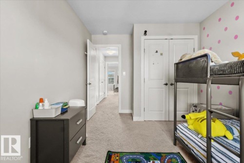 Carpeted room with a hallway entry, white paneled doors, and a decorative accent wall - 2847 Koshal Crescent, Edmonton, AB - Indoor Photo Showing Other Room