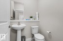Powder room featuring a pedestal sink with a chrome faucet, white toilet, and a wall-mounted mirror - 2847 Koshal Crescent, Edmonton, AB  - Indoor Photo Showing Bathroom 