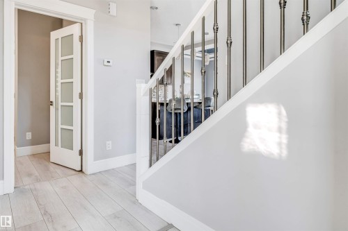 Staircase featuring decorative metal balusters and white handrails - 1103 29 Street, Edmonton, AB - Indoor Photo Showing Other Room