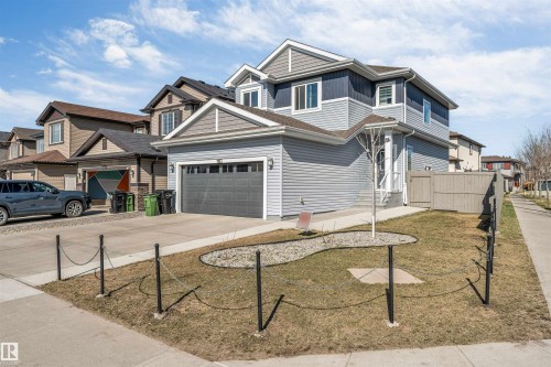 Modern two-story residence featuring light blue siding, darker blue upper paneling, a two-car garage, and a light-toned privacy fence - 1103 29 Street, Edmonton, AB - Outdoor With Facade
