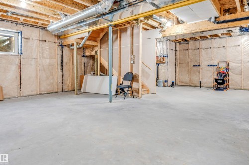 Unfinished basement with concrete flooring, exposed wood joists, and a visible window - 1103 29 Street, Edmonton, AB - Indoor Photo Showing Basement