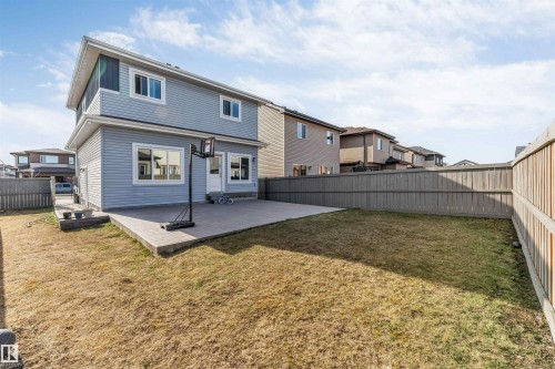 Spacious backyard featuring a concrete patio, expansive lawn area, and full perimeter wood fencing - 1103 29 Street, Edmonton, AB - Outdoor