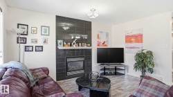 Living space featuring wood-finish flooring and a contemporary light fixture - 
