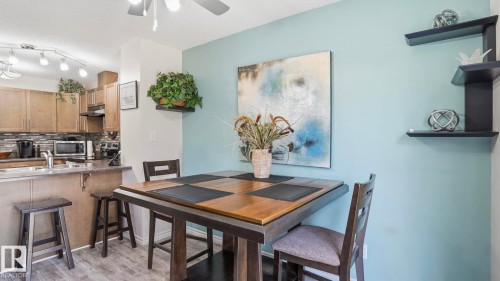 Dining area featuring a light blue accent wall and wood-finish flooring - 1709 64 Street, Edmonton, AB - Indoor Photo Showing Dining Room