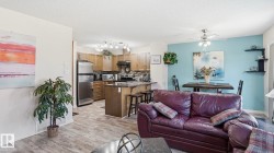 Open-concept living space featuring wood-finish flooring - 