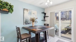 Dining area featuring light blue wall paint, wood-finish flooring, and a ceiling fan with integrated lighting - 