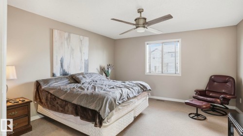 Spacious room featuring neutral-toned walls, carpeted flooring, a window with blinds, and a ceiling fan with integrated lighting - 1709 64 Street, Edmonton, AB - Indoor Photo Showing Bedroom