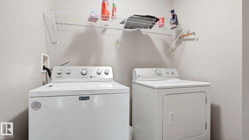 Dedicated laundry area featuring a white top-load washing machine and a white front-load dryer - 1709 64 Street, Edmonton, AB - Indoor Photo Showing Laundry Room
