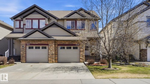 Two-story duplex featuring stone facade accents and horizontal siding - 1709 64 Street, Edmonton, AB - Outdoor With Facade