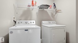 Dedicated laundry area featuring a white top-load washing machine and a white front-load dryer - 