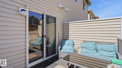 Private patio featuring a sliding glass door entry, siding exterior, and privacy screening - 1709 64 Street, Edmonton, AB - Outdoor With Exterior