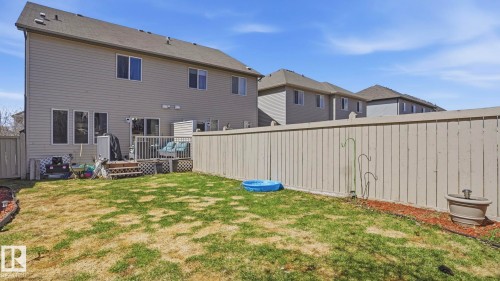 Private fenced backyard featuring a wood deck, siding exterior, and multiple windows - 1709 64 Street, Edmonton, AB - Outdoor With Exterior
