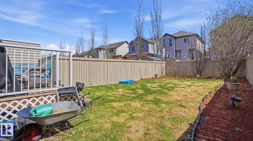 Expansive backyard featuring a wood deck with lattice skirting, aluminum railings, and a manicured lawn - 1709 64 Street, Edmonton, AB - Outdoor
