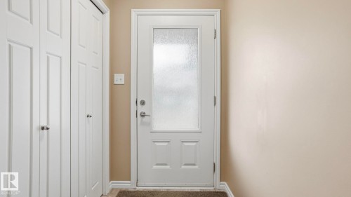 Entryway featuring a white paneled door with frosted glass, brushed nickel hardware, and neutral wall paint - 1709 64 Street, Edmonton, AB - Indoor Photo Showing Other Room