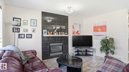 Living space featuring wood-finish flooring and a contemporary light fixture - 1709 64 Street, Edmonton, AB - Indoor Photo Showing Living Room With Fireplace